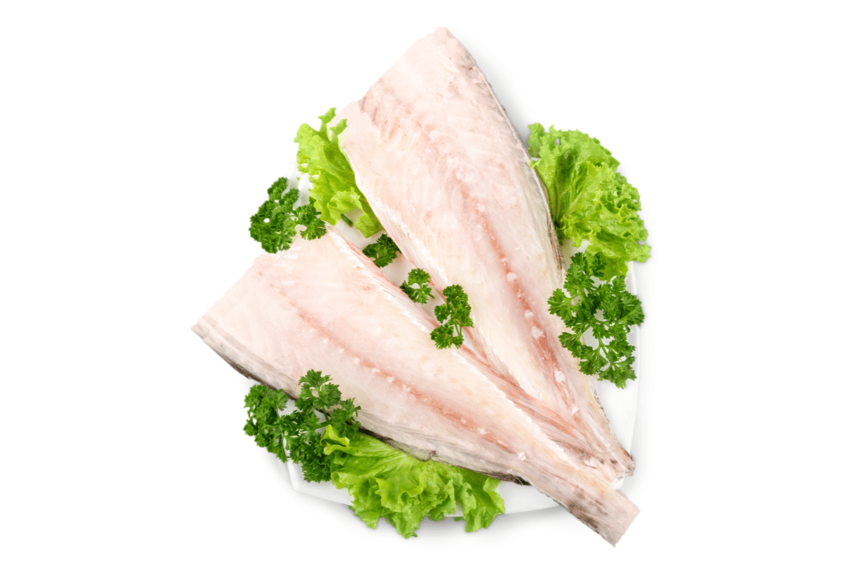 two raw cod fillets placed on a bed of fresh green lettuce leaves and garnished with parsley.