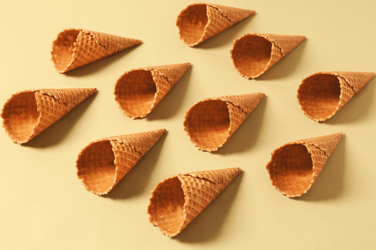 A set of empty chocolate waffle cones arranged on a light beige surface,